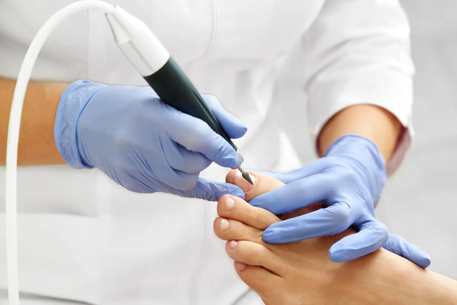 Professionelle Hardware-Pediküre mit elektrischer Maschine. Patient bei medizinischer Pediküre, Besuch beim Podologen. Füße mit speziellem elektrischen Gerät peelen. Fußbehandlung im SPA-Salon. Podologische Klinik.